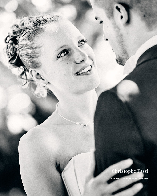 Mariée qui regarde son marié en souriant, portrait de couple en noir et blanc